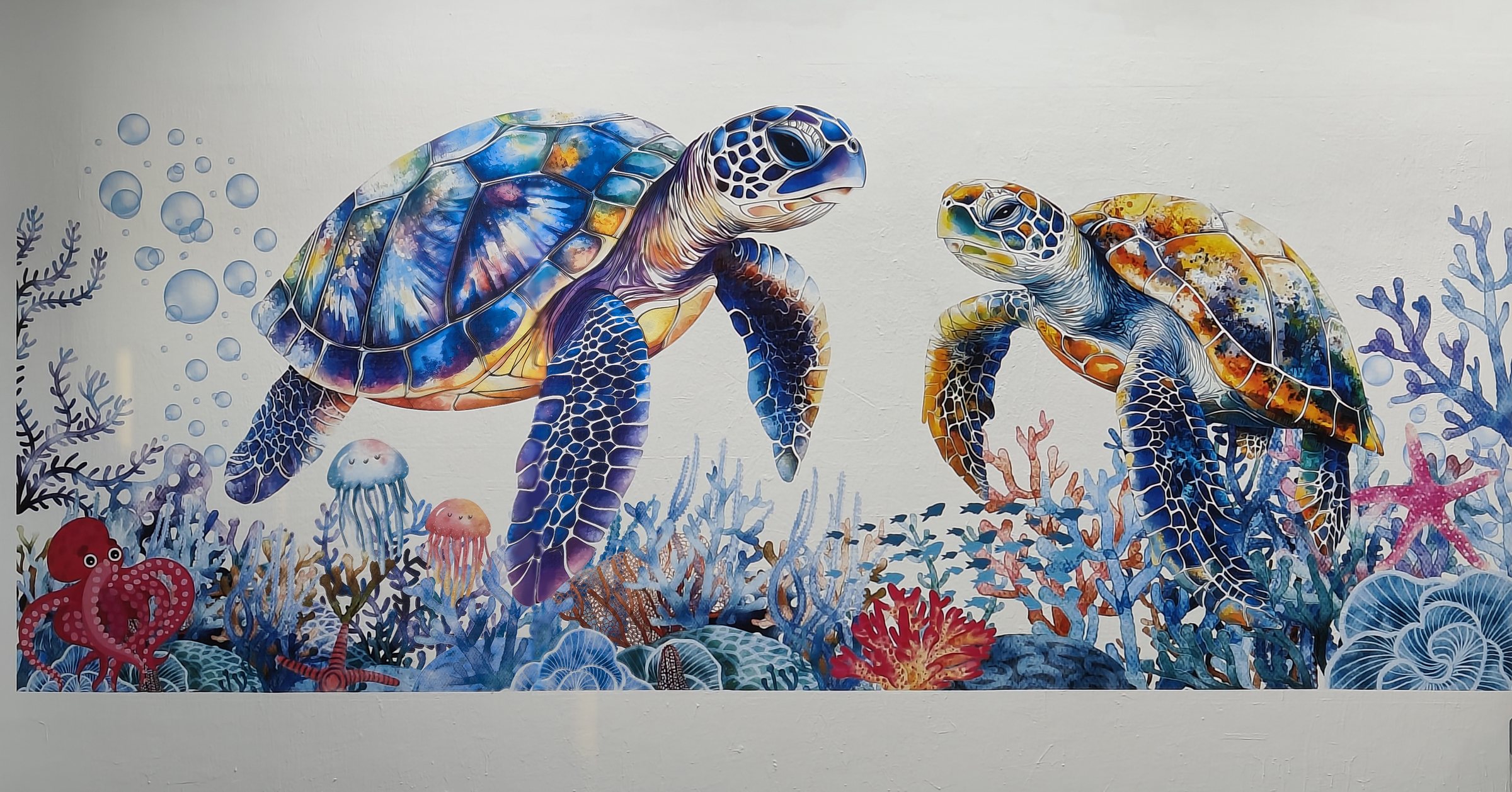 Two sea turtles and a coral reef printed across a full interior wall, printer on its rail alongside