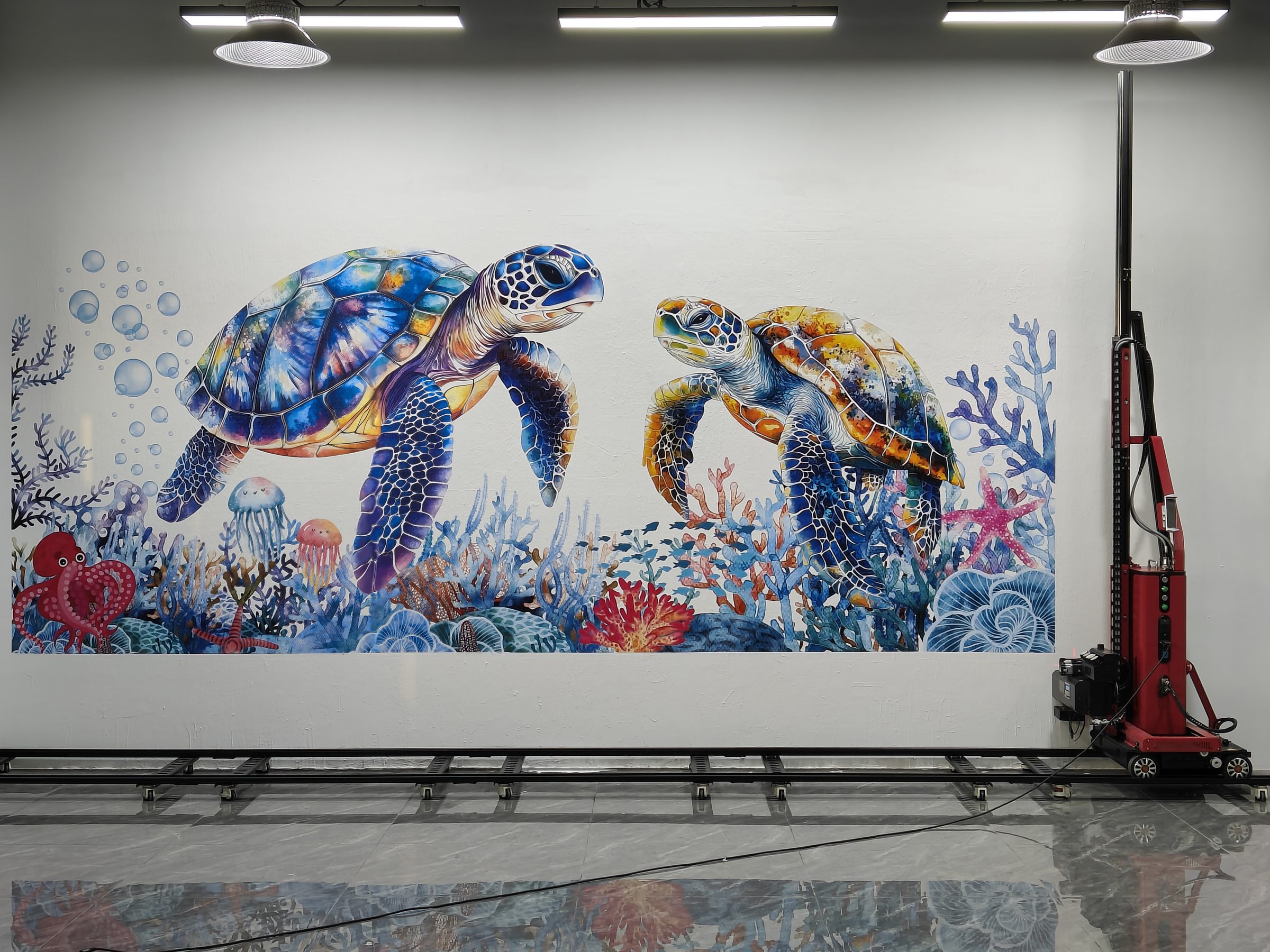 Two sea turtles and coral printed directly onto an interior wall, with the printer on its rail alongside